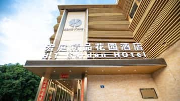 The exterior of the Garden Hotel with a prominent sign and a clock above the entrance.