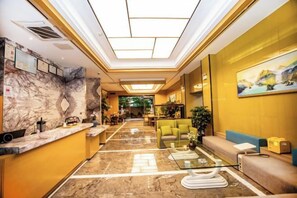 A hotel lobby with a marble reception desk, seating area, and a painting on the wall. - Hongting Garden Hotel (Kunming)