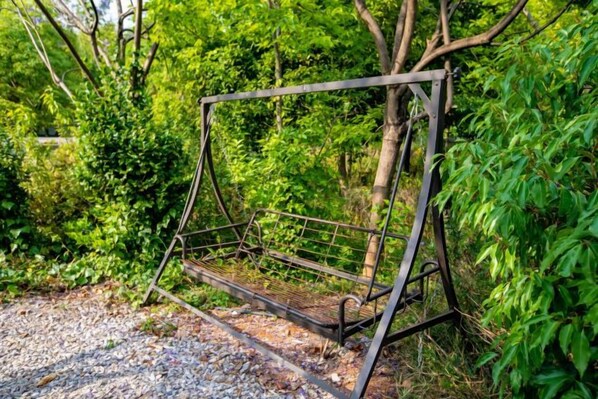 A metal structure, possibly a gate or fence, in a natural setting with dense foliage. - Hongting Garden Hotel (Kunming)