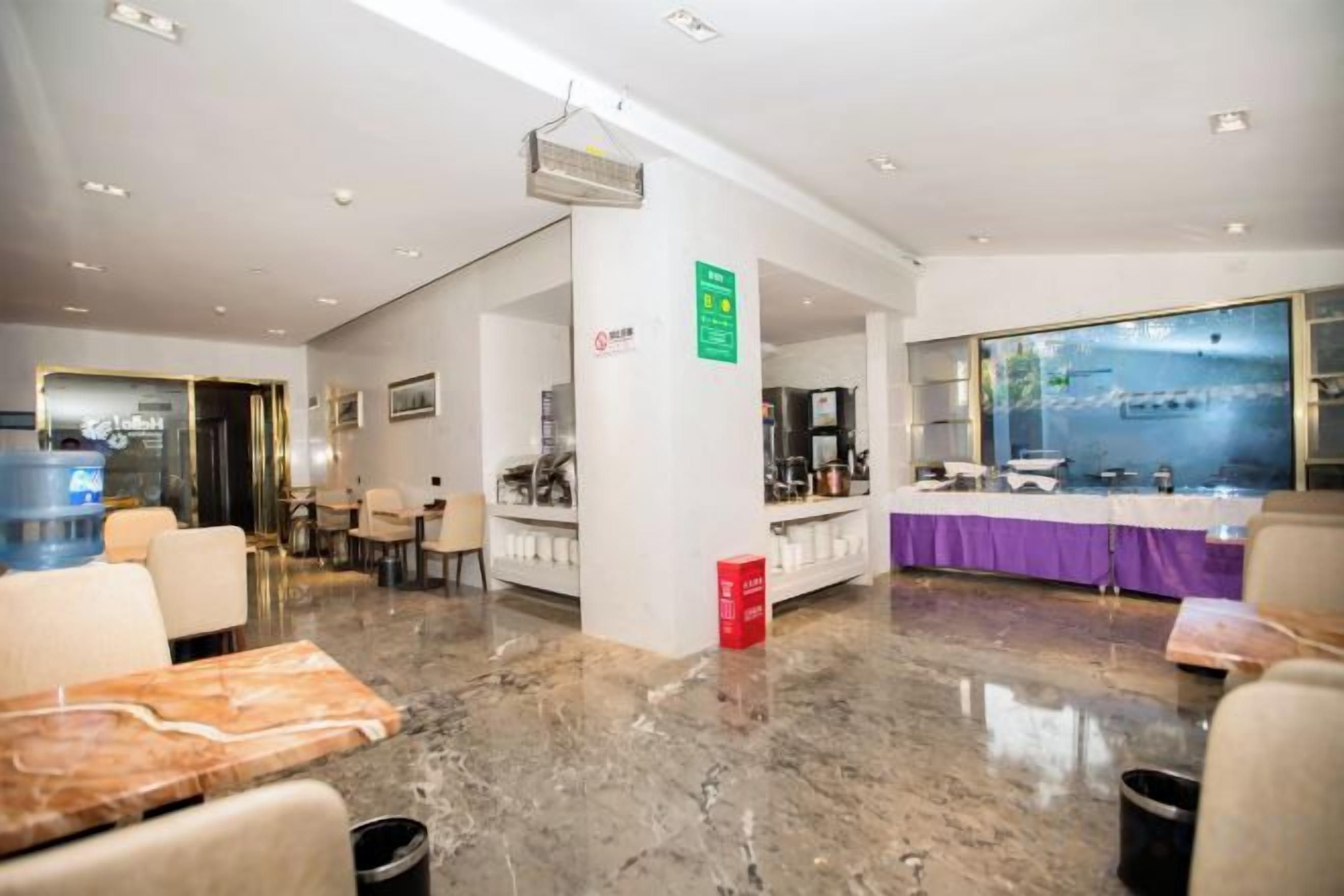 Una hall d'albergo con reception, zona salotto e una grande vetrata.