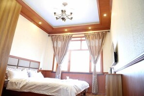 Ein Schlafzimmer mit Bett, Vorhängen, einer Chandelieber und einem Fenster.