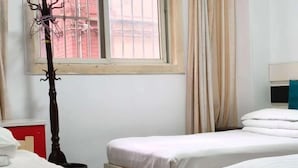 A hotel room with two beds, a window with curtains, a red cabinet, and a black floor lamp. - Shanghai Xinyao Hotel (Minhang Jiangchuan Road Subway Station Branch) (Shanghai)