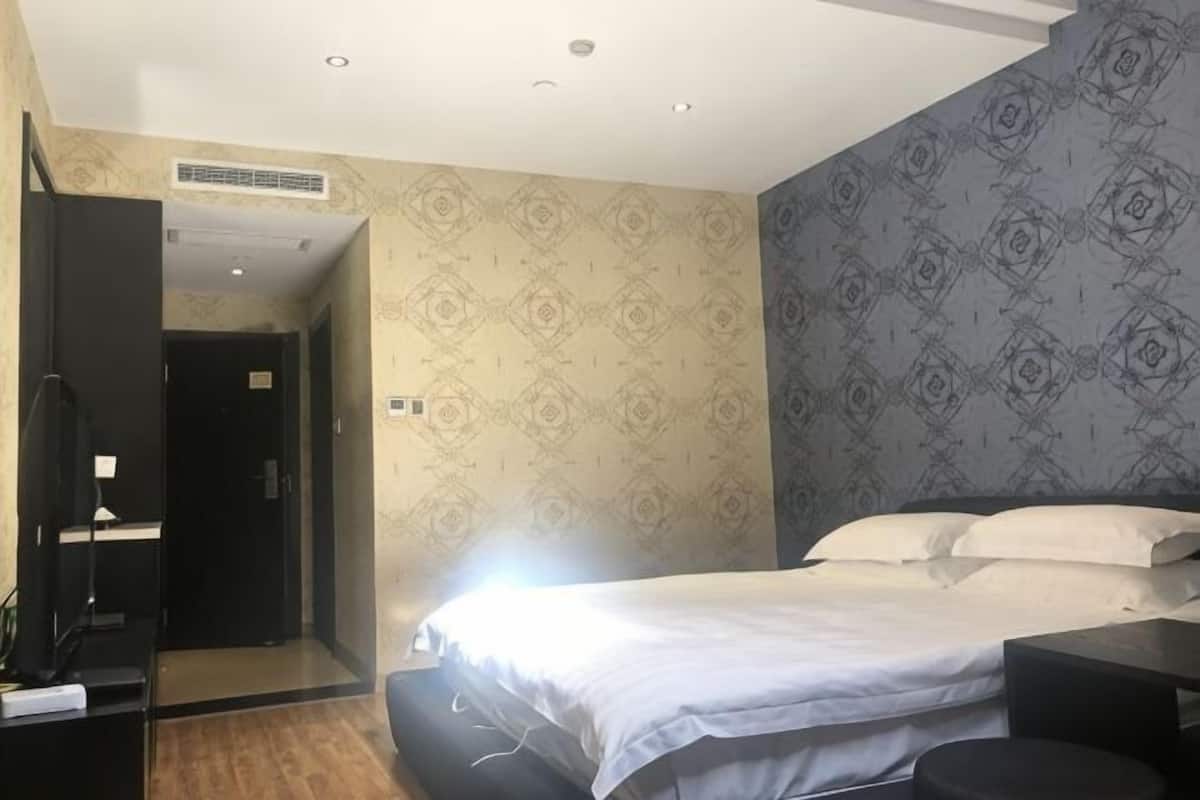 Un dormitorio con cama, escritorio y armario.