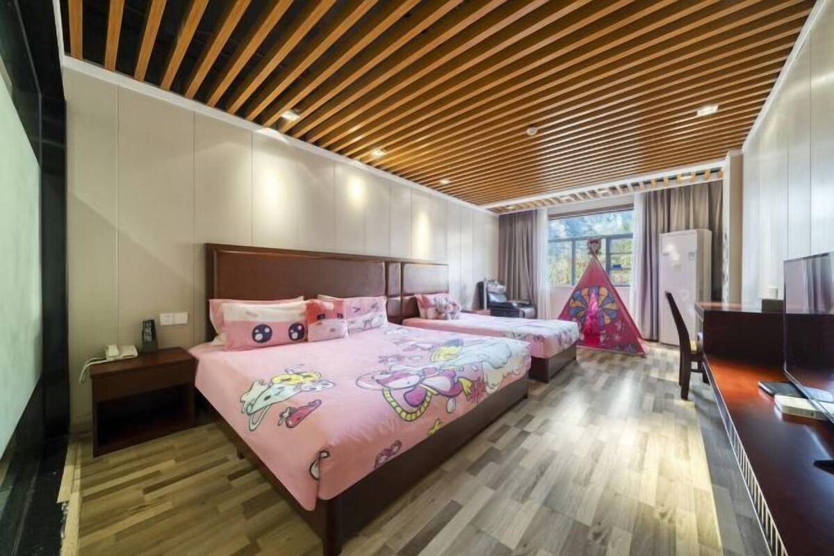 Un dormitorio con dos camas, un escritorio y una ventana con cortinas.