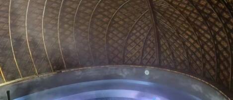 A hot tub with a curved ceiling and a steam vent.