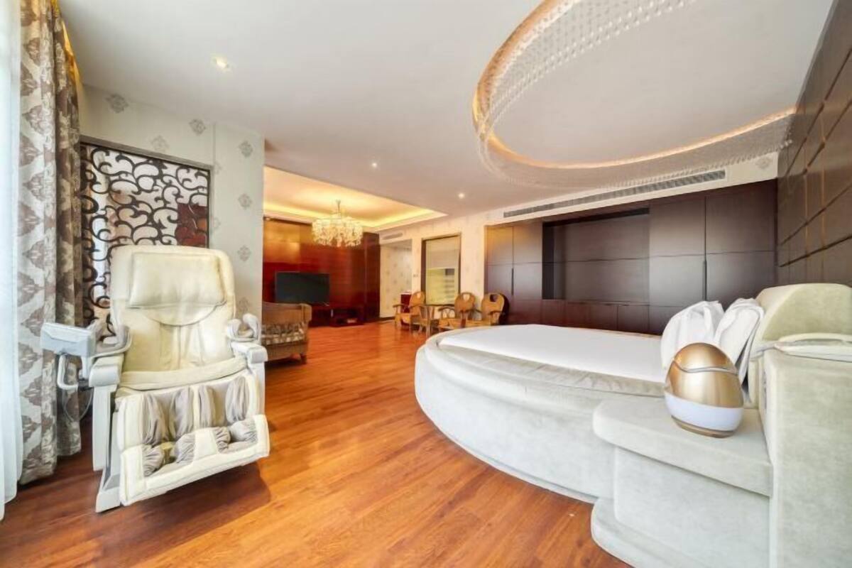 Un amplio salón con un sofá grande, un sillón reclinable y un televisor de pantalla plana.