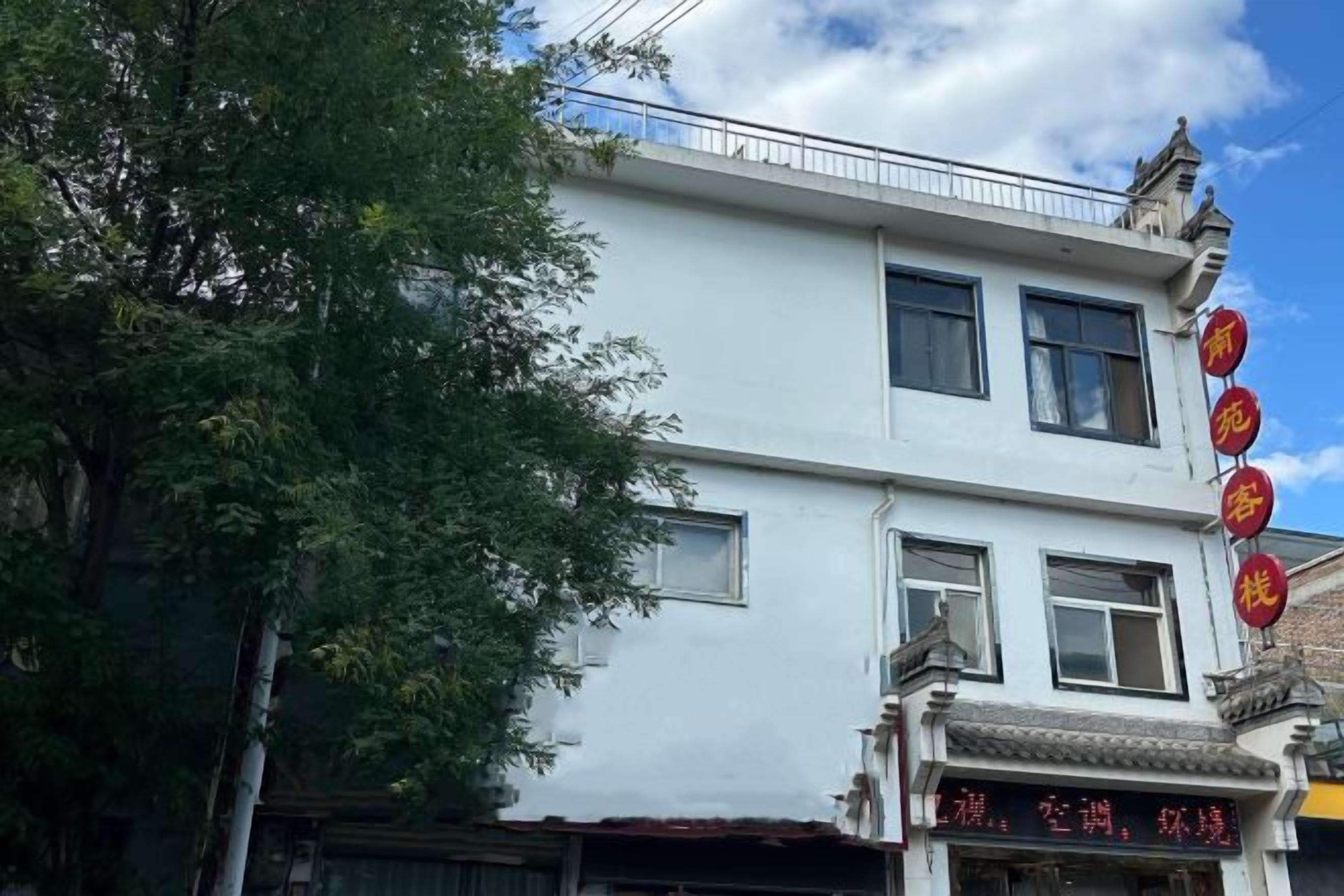 A two-story building with traditional architectural elements, including a balcony and a sign with Chinese characters.