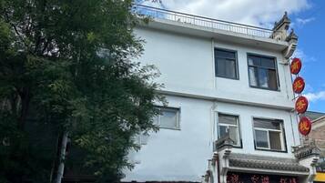 A two-story building with traditional architectural elements, including a balcony and a sign with Chinese characters.