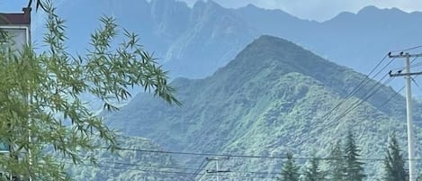 A mountain landscape with a building in the foreground.