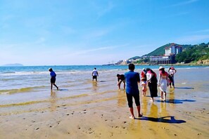 Una playa con gente caminando por la orilla.