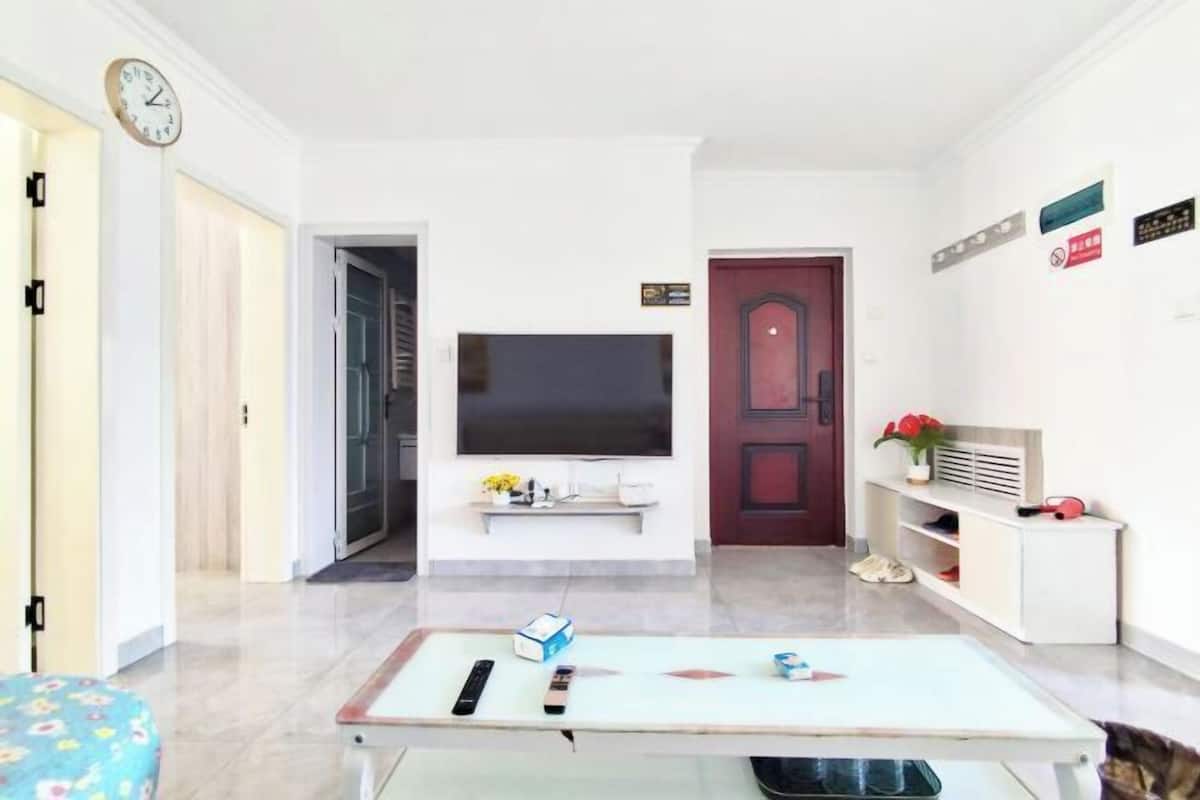 A living room with a TV, a coffee table, and a sofa.