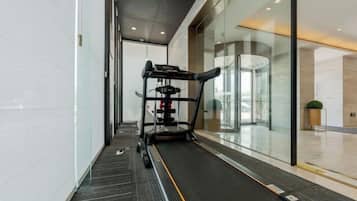 A gym area with a treadmill, weight machine, and exercise equipment.