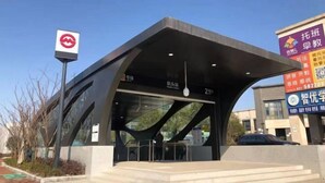 A modern building with a unique architectural design, featuring a prominent overhang and glass facade. - Easy Go Inn (Shanghai Hangtou Hunan Highway Store) (Shanghai)