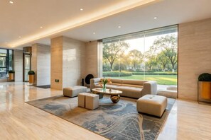 A modern lobby with a large window, a sofa, a coffee table, and a rug. - Easy Go Inn (Shanghai Hangtou Hunan Highway Store) (Shanghai)