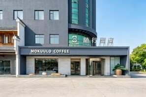 A modern building with a coffee shop named 'MOKUULO COFFEE' on the ground floor.