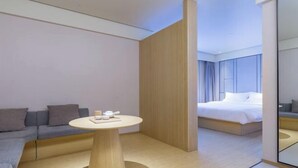Une chambre d’hôtel moderne avec un canapé, une table ronde et un lit.