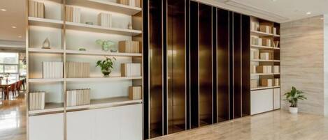 Un interior moderno con una estantería empotrada, una planta en maceta y suelo de madera.