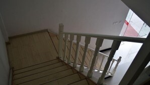 A wooden staircase with white balusters leading to a landing. - Hefeng Hotel (Jing County)