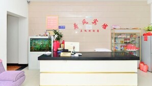A reception area with a counter, a fish tank, and a shelf with various items. - Hefeng Hotel (Jing County)
