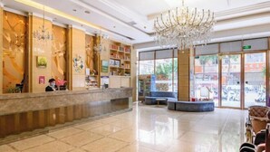 A hotel lobby with a reception desk, bookshelves, a chandelier, and a seating area. - Heng Da Hotel (Yulin Railway Station Zhongyaogang) (Yulin)