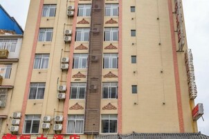 Un edificio de varios pisos con unidades de aire acondicionado, una escalera central y una serie de ventanas.
