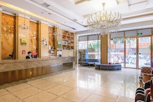 Un vestíbulo de hotel con mostrador de recepción, un candelabro y una zona de estar.