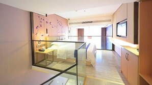 A modern hotel room with a glass partition, a bed, a desk, and a television. - Heng Da Hotel (Yulin Railway Station Zhongyaogang) (Yulin)