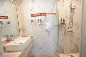 A bathroom with a white sink, a glass shower enclosure, and a marble wall. - Heng Da Hotel (Yulin Railway Station Zhongyaogang) (Yulin)