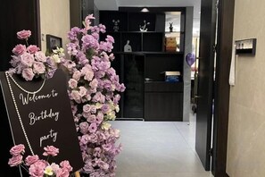 Una porta amb un senyal que diu 'Feliç aniversari' i un arranjament floral.