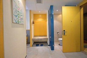 A bathroom with a yellow door, a toilet, and a shower area. - Heng Da Hotel (Yulin Railway Station Zhongyaogang) (Yulin)