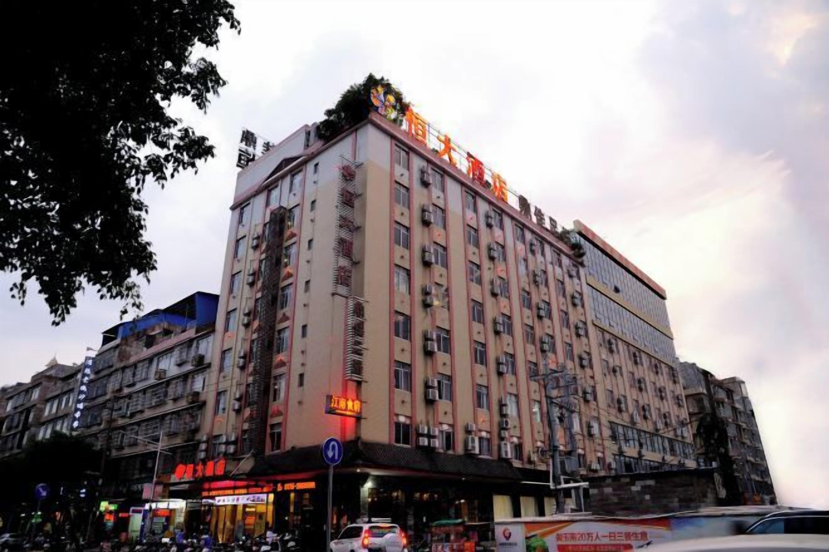 Un hôtel à plusieurs étages, avec une enseigne bien visible au sommet, de nombreuses fenêtres et une entrée au niveau du sol, également signalée.