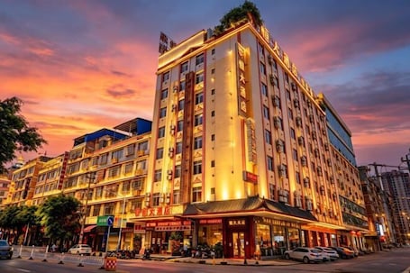 A multi-story hotel with a traditional architectural style, featuring a prominent entrance with signage.