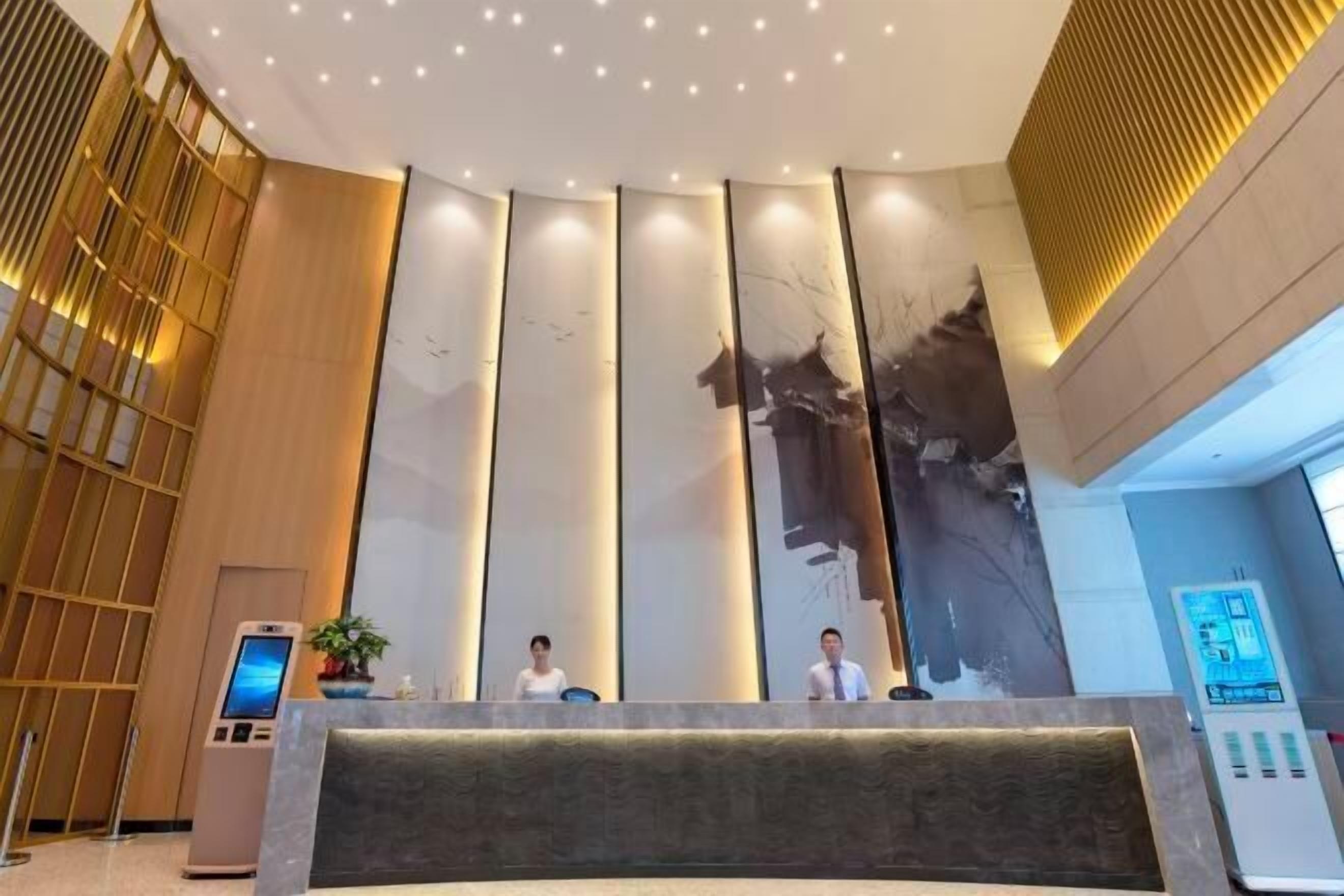 Et moderne receptionområde med en stor digital skærm, et receptionsskrivebord og en lodret lyseinstallation.