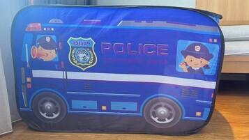 A blue suitcase with police-themed designs, including a police car and badge.