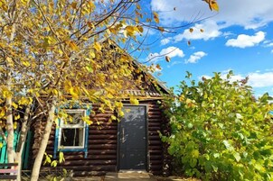 Una cabaña de troncos con puerta cerrada, una ventana y un porche.