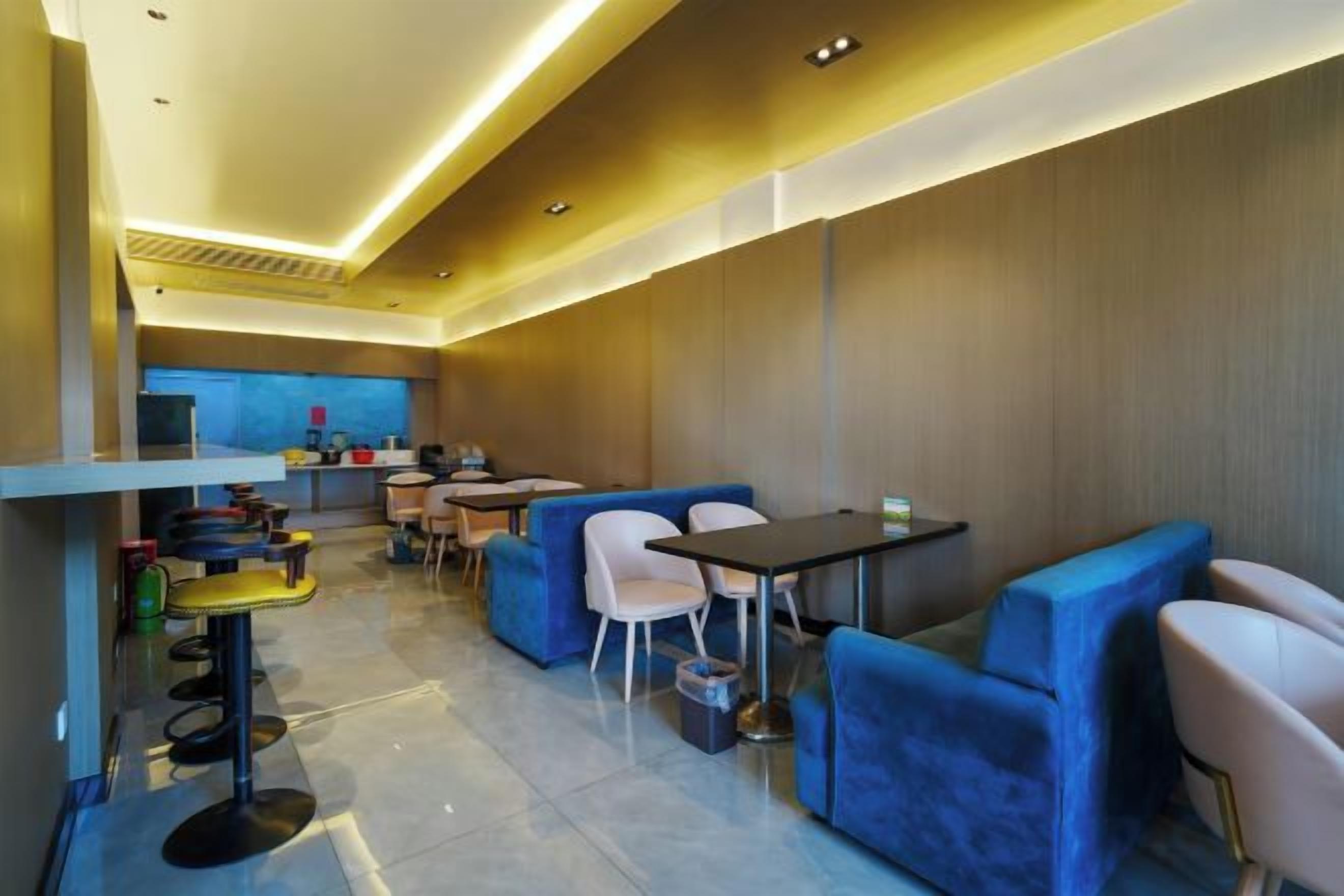 A modern interior with seating areas, tables, and a kitchen in the background.