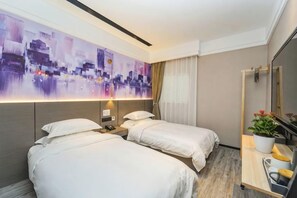 A hotel room with two beds, a large abstract painting, a bedside table with a lamp, a mirror, and a potted plant. - Rest Motel (Shanghai)