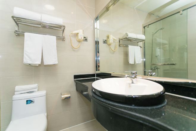 A modern bathroom with a round sink, a glass shower enclosure, and a mirror above the sink.