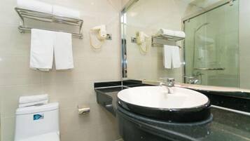 A modern bathroom with a round sink, a glass shower enclosure, and a mirror above the sink.