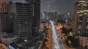 A nighttime cityscape with high-rise buildings, busy roads, and a clear view of the urban environment. - Xinrenren hotel (Shanghai)