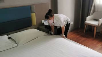A hotel room with a bed, a chair, and a nightstand.