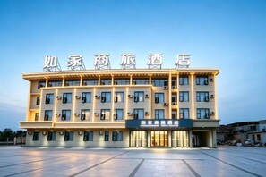 A hotel with a flat facade, multiple windows, and a sign with Chinese characters. - Homeinn Selected Hotel (Chuzhou Mingguang Mingzhu Avenue Zhengyuan Plaza) (Mingguang)