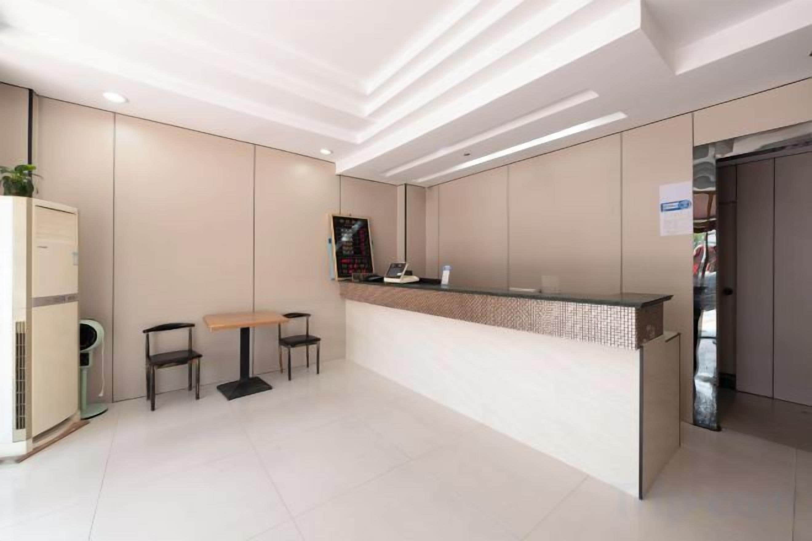 A reception area with a counter, two chairs, a small table, and a cabinet.