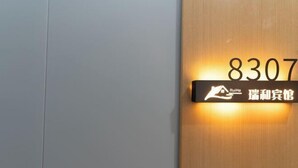 A hotel sign with the number 8307 and a logo. - Ruihe Hostel (Shanghai)