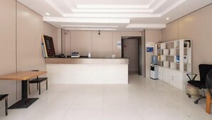 A reception area with a counter, seating, and a water dispenser. - Ruihe Hostel (Shanghai)