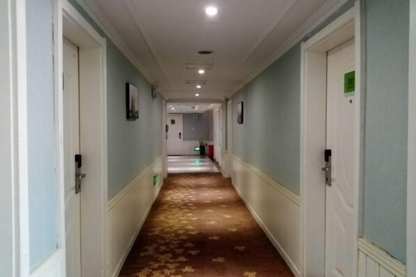 A hotel corridor with doors on both sides, a carpeted floor, and a light-colored ceiling. - Morning Inn Hotel (Yanling County Government) (Yanling)