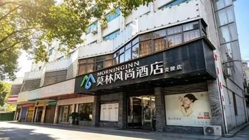 A hotel with a prominent sign, multiple floors, and a storefront.