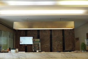 A reception area with a marble reception desk, a flat-screen TV, and a sign above the desk. - Morning Inn Hotel (Yanling County Government) (Yanling)