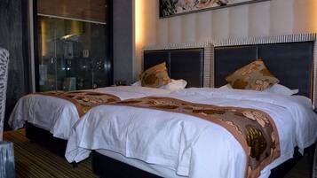 A double bed with a headboard, a window with a view, and a painting on the wall.