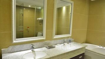 A bathroom with two sinks, a bathtub, and two large mirrors.